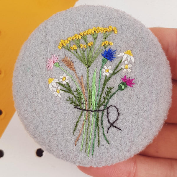 grey floral badge