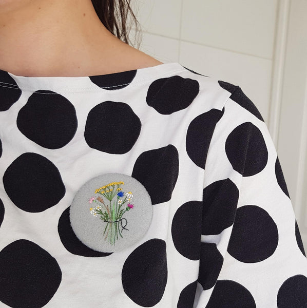 grey floral badge