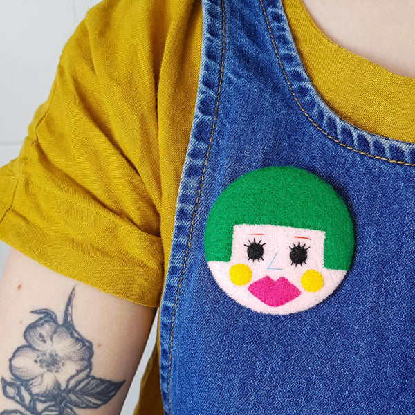 green bobbed hair face badge being worn