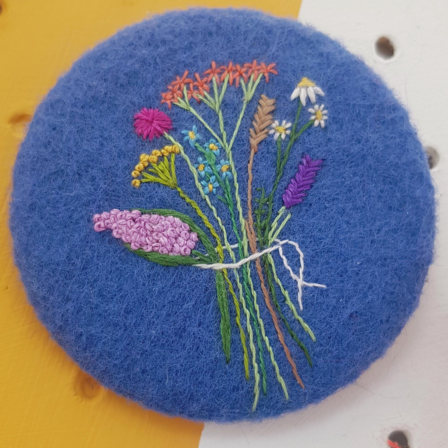 embroidered floral badge on blue felt