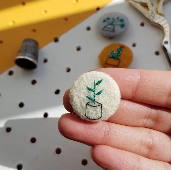 white embroidered plant badge